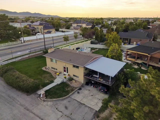 Two-story residence with a metal carport, concrete driveway, and a covered balcony