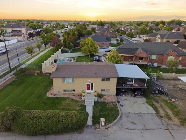Split-level residence featuring a covered deck, carport, concrete entryway, and mature landscaping