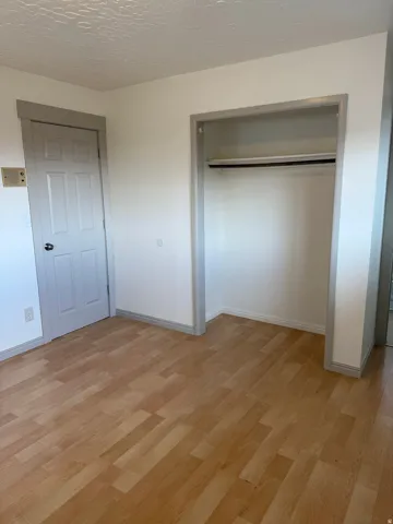 Wood-finish flooring with neutral wall paint and trim. Photo shown was taken prior to tenant occupancy and is provided for reference.