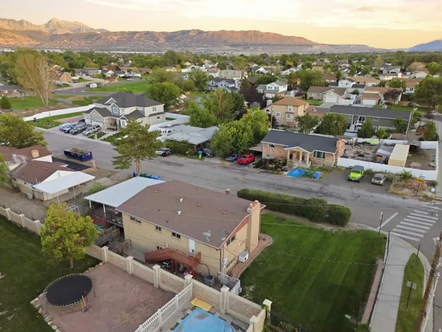 Expansive neighborhood setting with mountain backdrop and mature trees