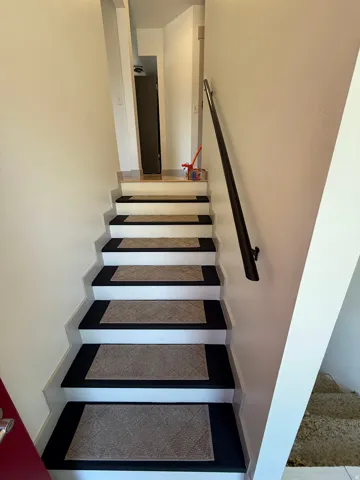 White painted staircase with accented risers and a contrasting handrail. Photo shown was taken prior to tenant occupancy and is provided for reference.