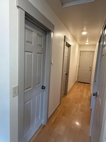 Recessed ceiling lighting, wood-finish flooring, paneled interior doors, and neutral wall tones. Photo shown was taken prior to tenant occupancy and is provided for reference.