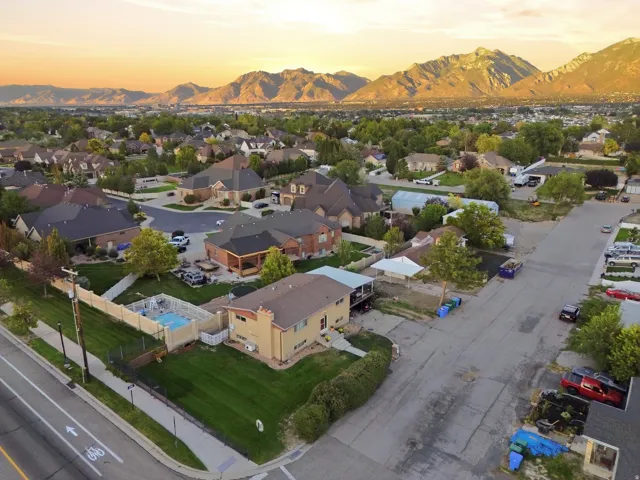 Mountain landscape, suburban residential setting, paved streets, maintained landscaping, fenced backyard, inground swimming pool