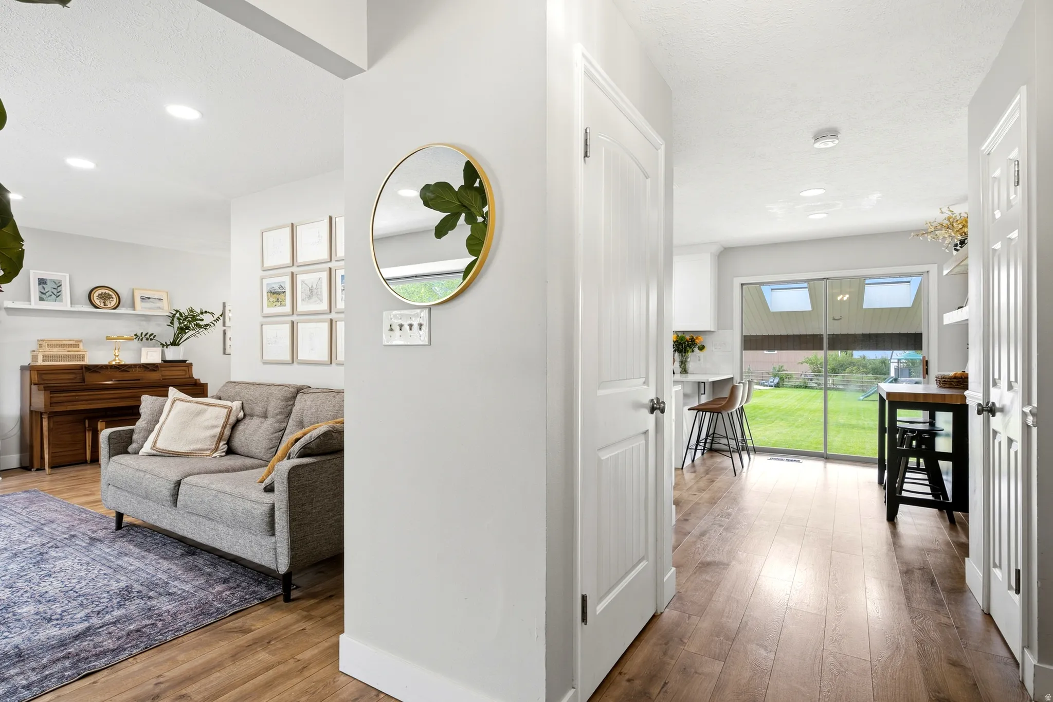 Wood-finish flooring throughout, recessed lighting, and a sliding glass door with skylights