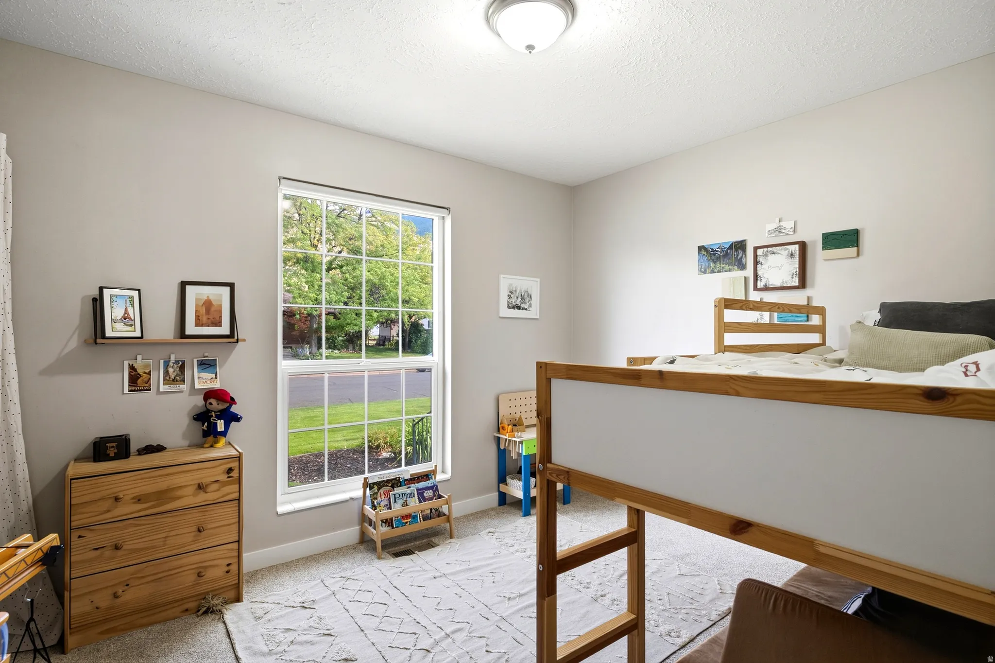 Recessed ceiling light fixture, framed window with grid pattern, light-colored wall paint, light-toned carpeting, and a built-in floating shelf