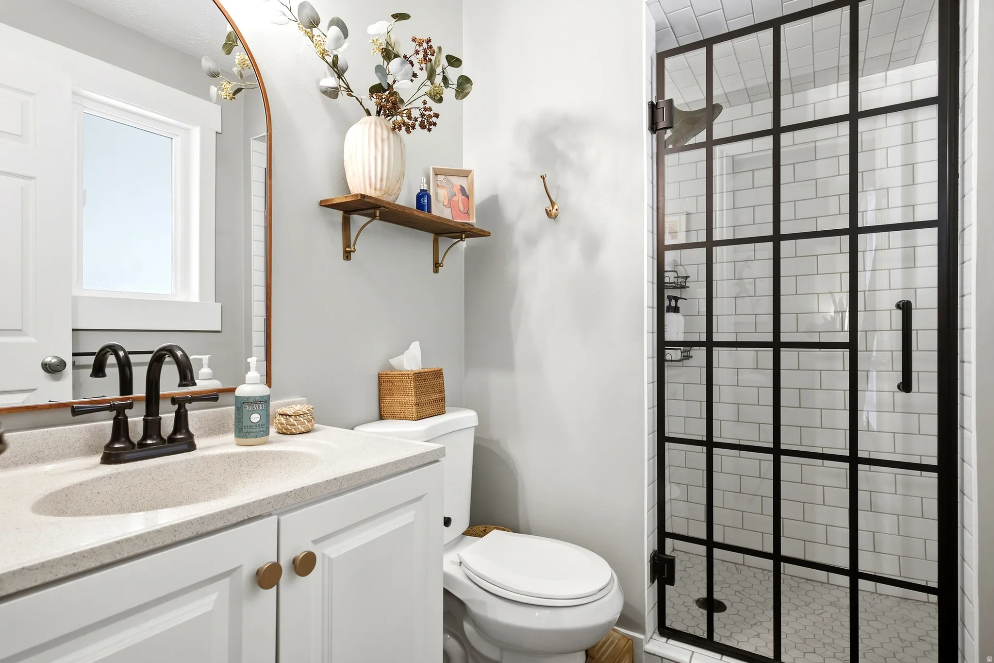 White vanity with an integrated sink and bronze hardware