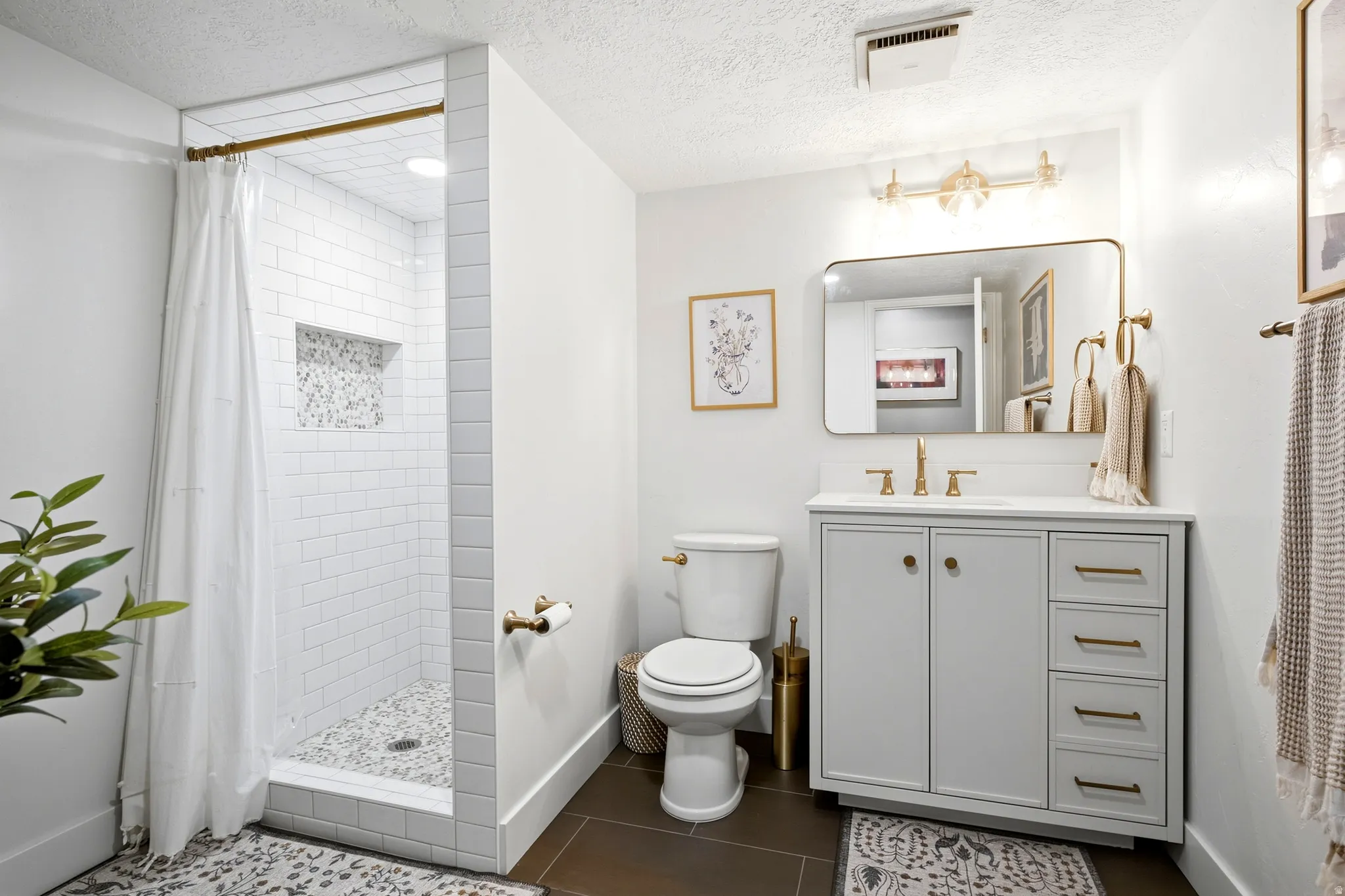 Walk-in shower with subway tile surround and pebble-finish floor