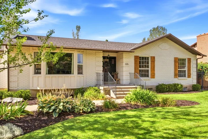 White brick exterior with a dark shingle roof