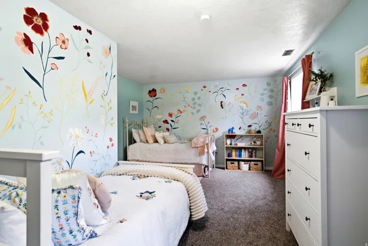 Wall-to-wall carpeting, light blue walls with floral patterns, and a built-in shelving unit