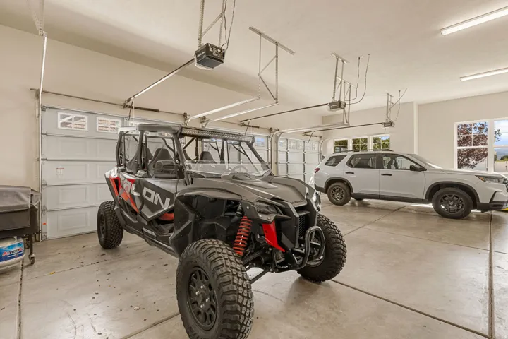 Attached garage with two overhead doors and concrete flooring