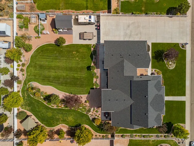 Expansive landscaped grounds with a large lawn area, mature trees, and a paved patio