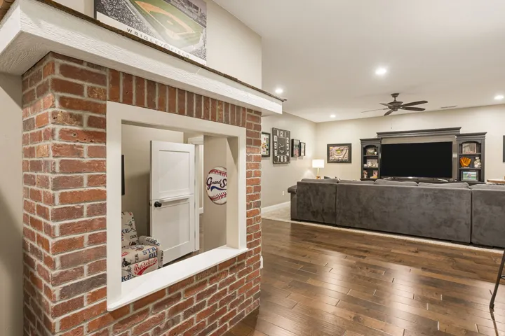 Exposed brick architectural element with a pass-through window, recessed lighting, wood-finish flooring, and a ceiling fan