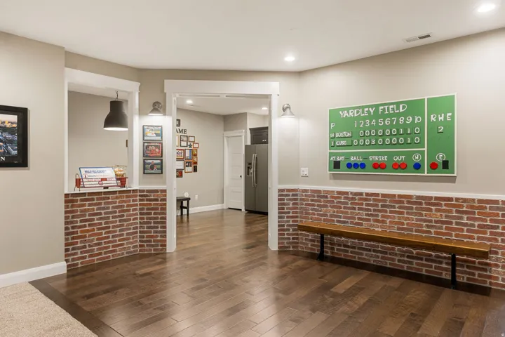 Wood-finish flooring, brick-accented walls, recessed lighting, and white trim details