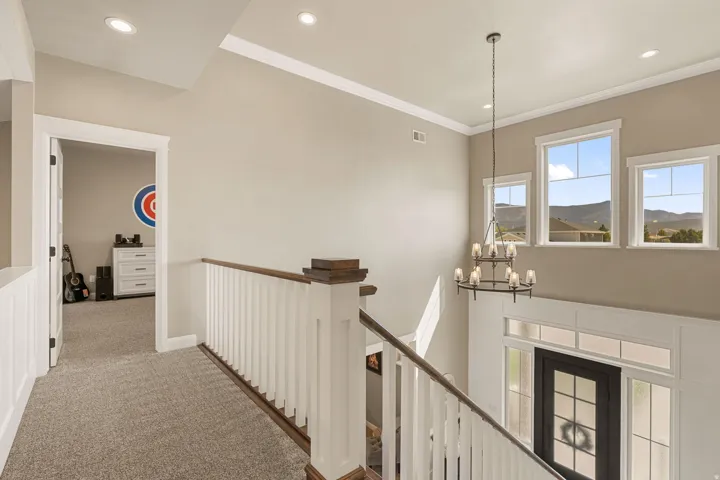 Entryway featuring a decorative chandelier, multi-pane windows, and a black front door with sidelights