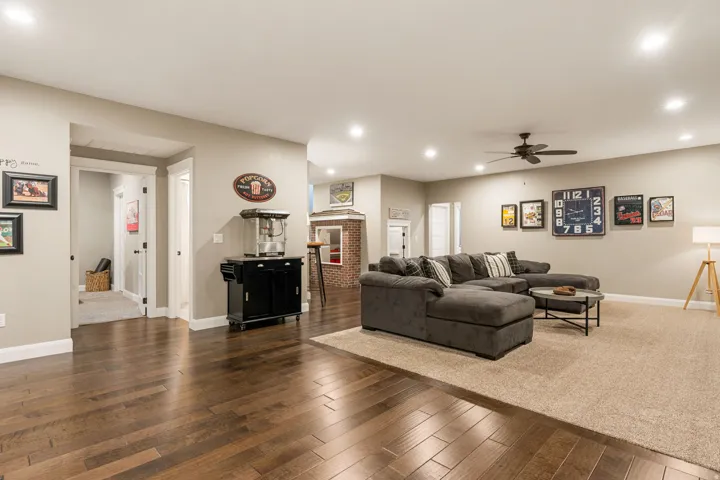 Wood-finish flooring, recessed lighting, ceiling fan, and neutral wall tones