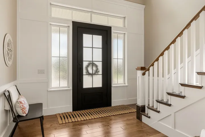 Hardwood flooring, dark-finish entry door with frosted glass, sidelight windows, transom windows, and a staircase with wood-finish handrail and white balusters