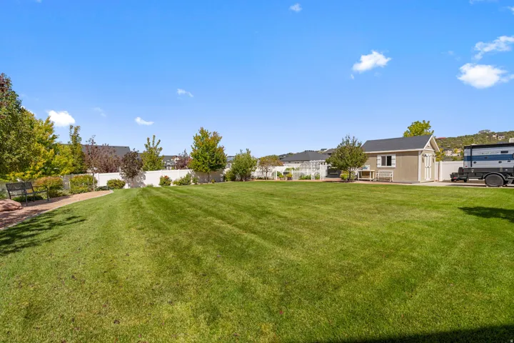 Expansive manicured lawn with mature landscaping and established trees, offering generous outdoor space