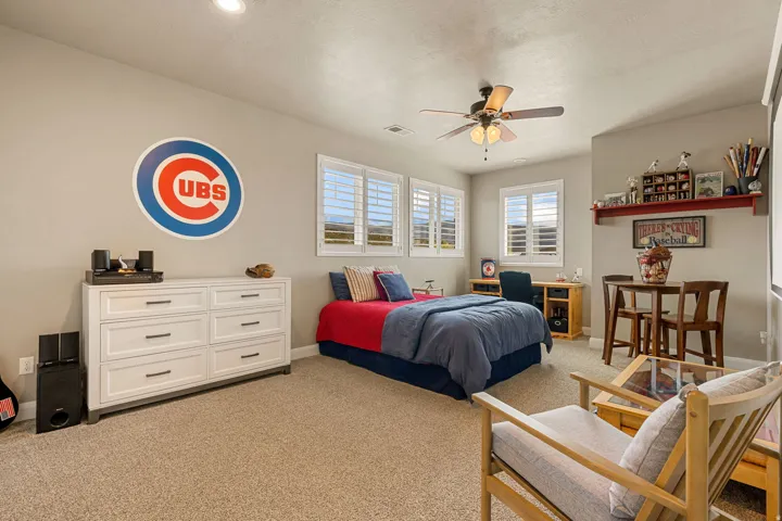 Recessed ceiling lighting, ceiling fan with integrated lighting, multiple windows with white shutters, wall-mounted shelving