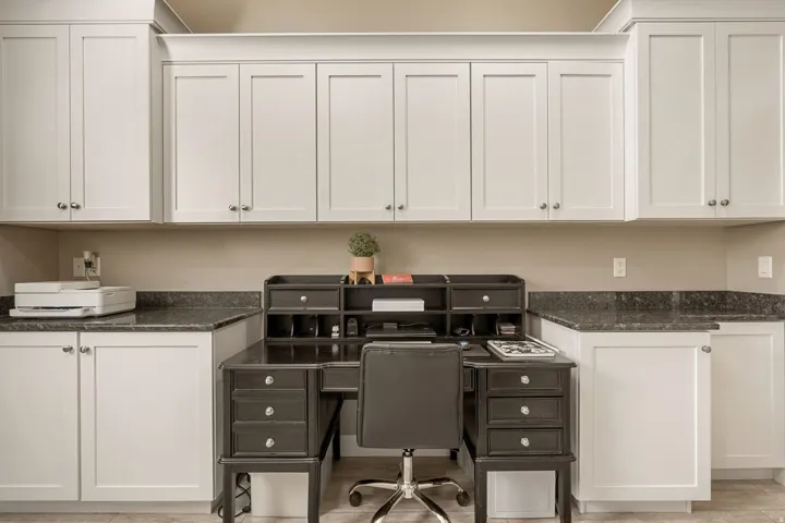 Built-in white shaker-style cabinetry with stone-finish countertops