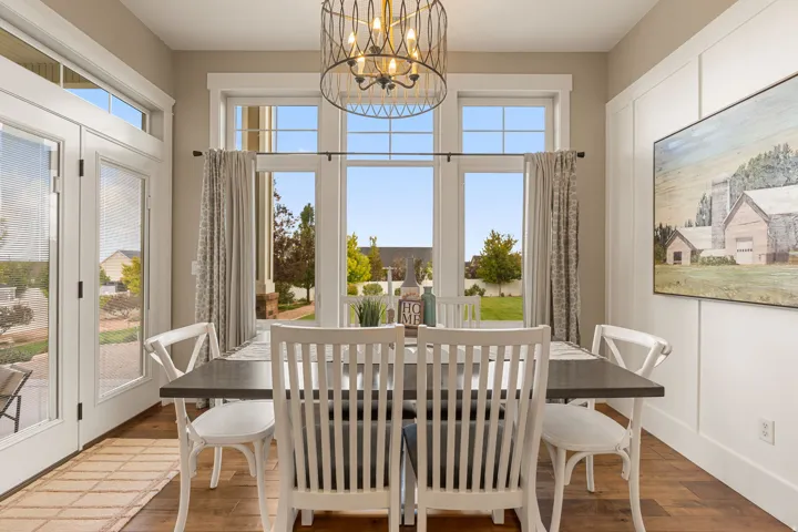 Hardwood-style flooring, white paneling, and an ornate chandelier