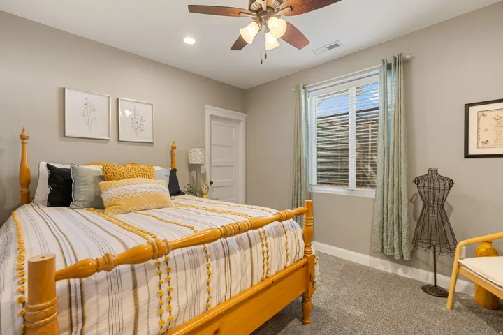 Recessed lighting, ceiling fan with light fixture, neutral wall color, egress window with blinds, and paneled interior door