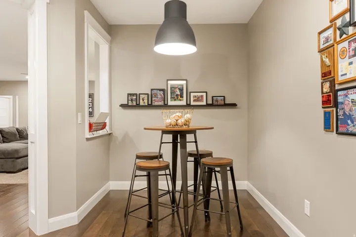 Wood-finish flooring with white trim, a built-in display shelf, a pass-through opening, and a ceiling-mounted pendant light fixture