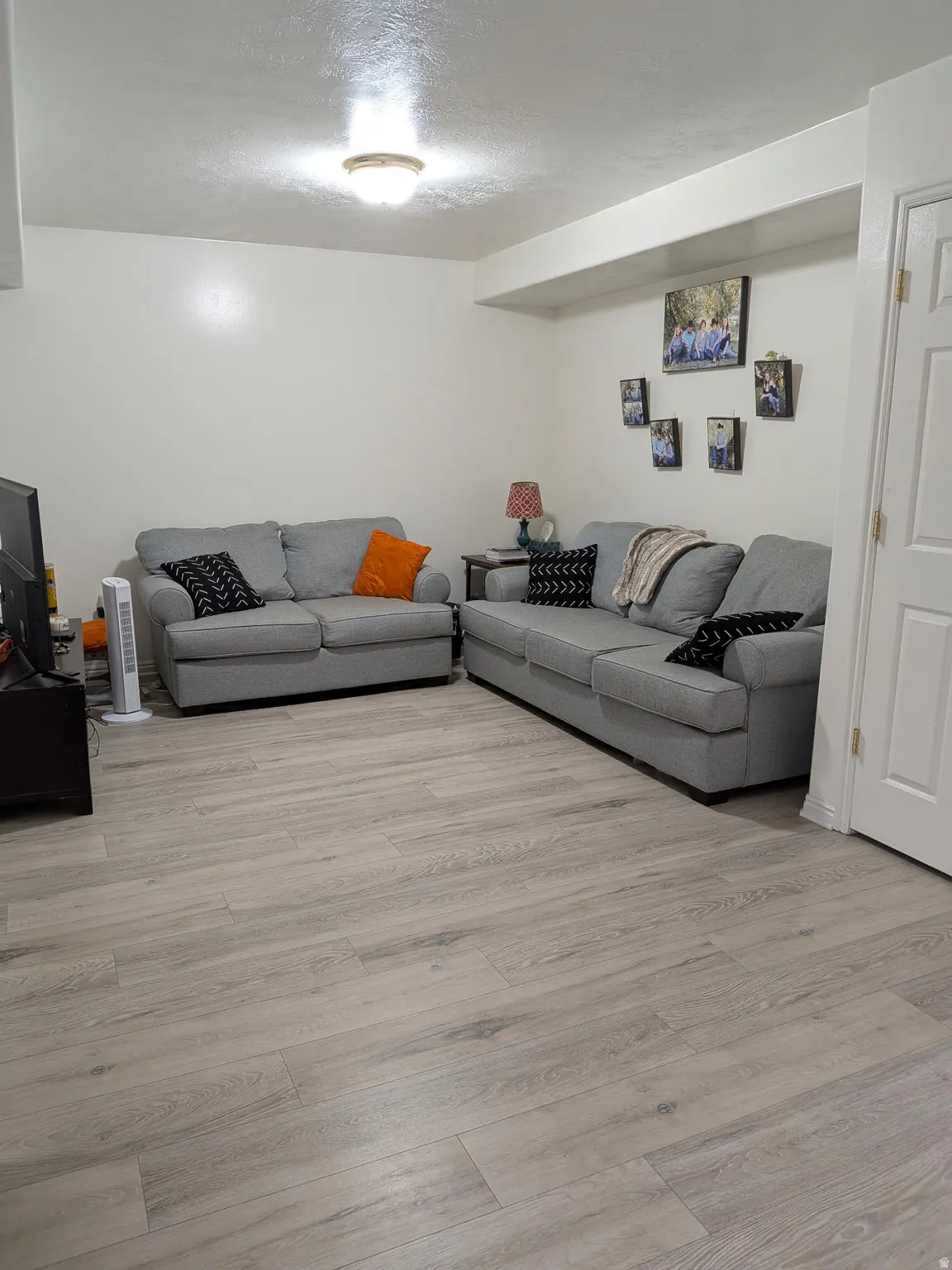 Light wood-finish flooring with white walls and a white door