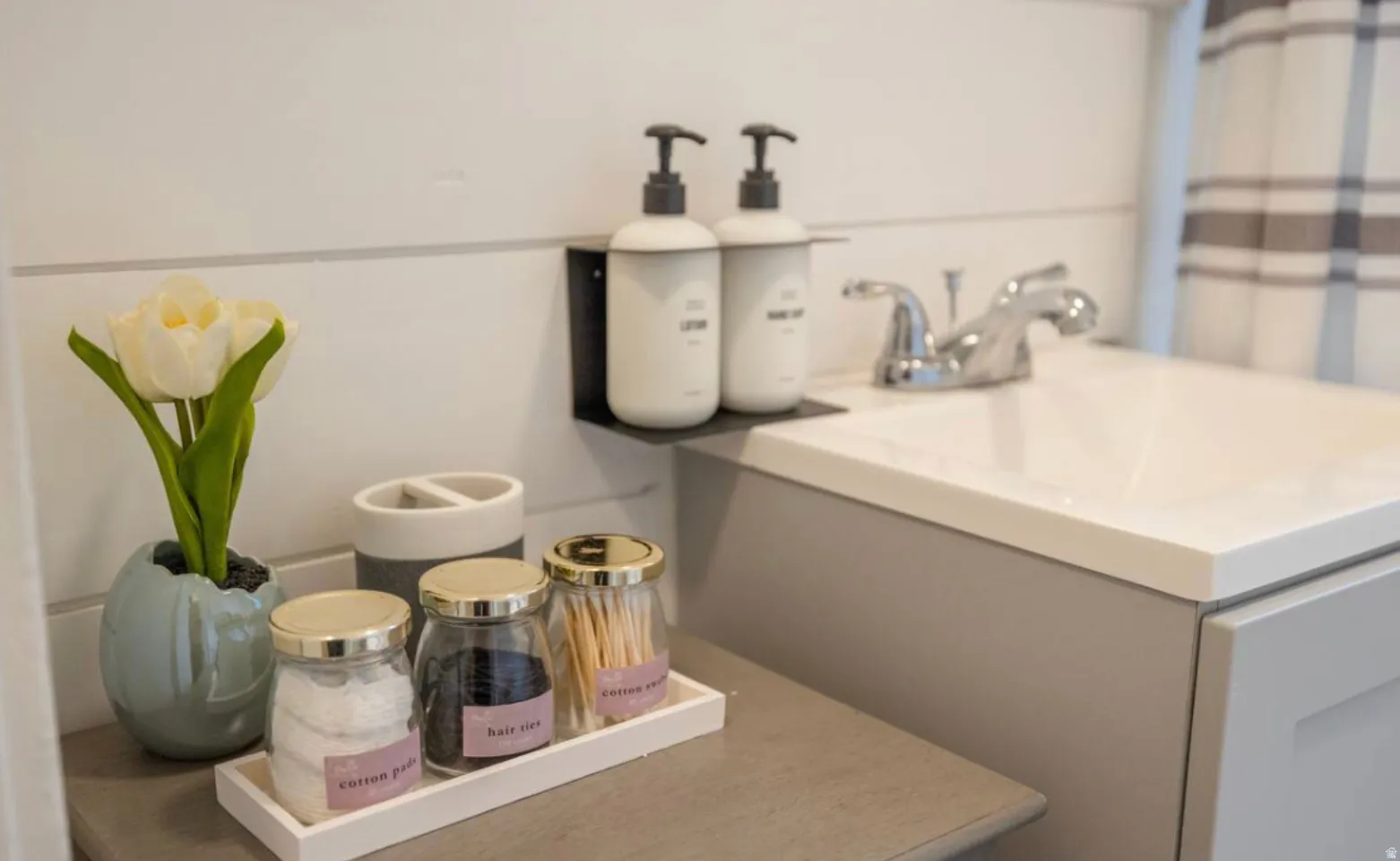 White integrated sink with a chrome faucet, gray vanity, and shiplap wall paneling