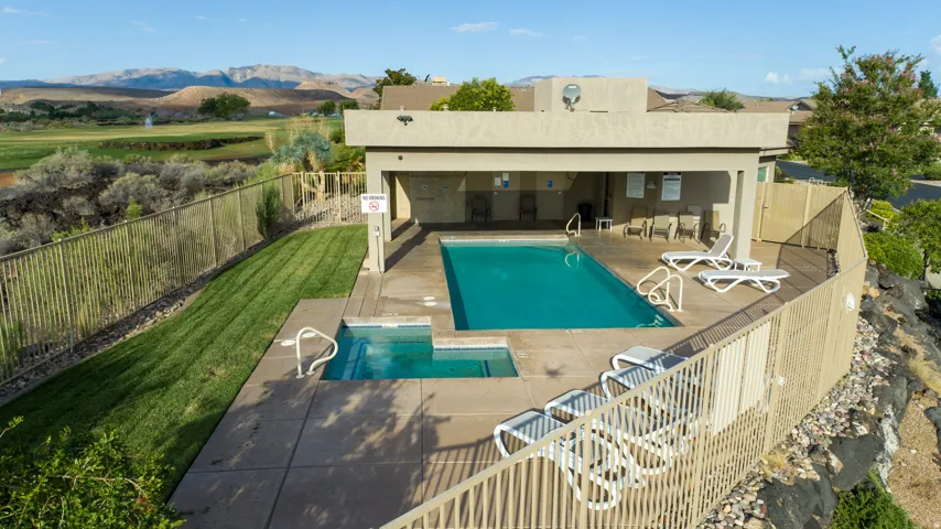 Outdoor swimming pool with integrated spa and surrounding concrete decking