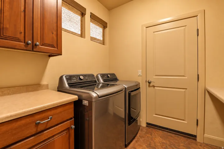 Wood-finish flooring with upper and lower cabinetry, and a light-toned countertop