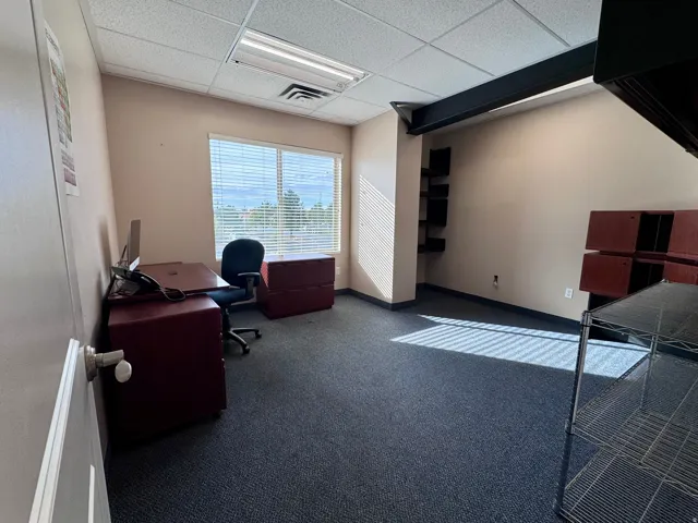 Unit A- Recessed lighting with a drop ceiling, carpeted flooring, and a large window with blinds