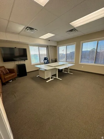 Unit D- Carpeted flooring, multiple windows, recessed lighting, and a drop ceiling