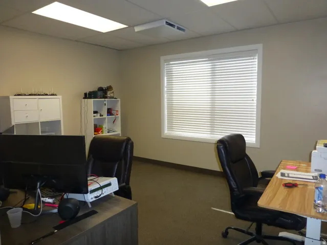 Unit D- Recessed lighting fixtures, drop ceiling, window with white blinds, and light-colored walls