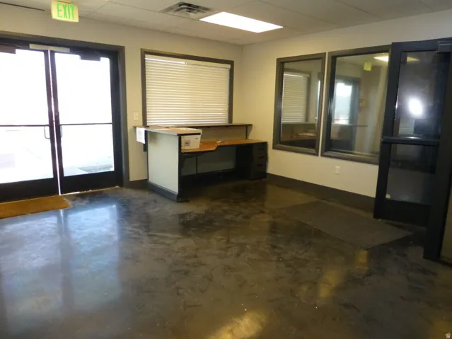 Unit D Lobby- Polished concrete flooring, recessed lighting, double glass entry doors, built-in reception desk, and interior glass panels