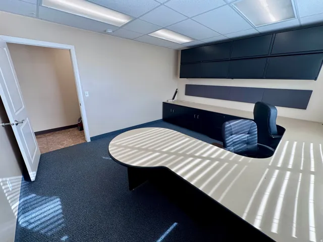 Unit A- Recessed lighting, drop ceiling, wall-mounted cabinetry, built-in desk, and carpet flooring