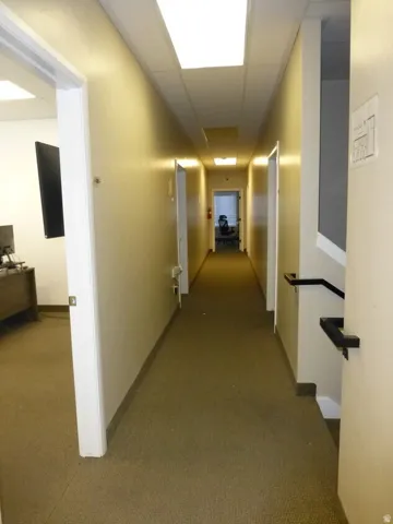Unit D Carpeted hallway with flush-mounted ceiling lights and multiple entryways