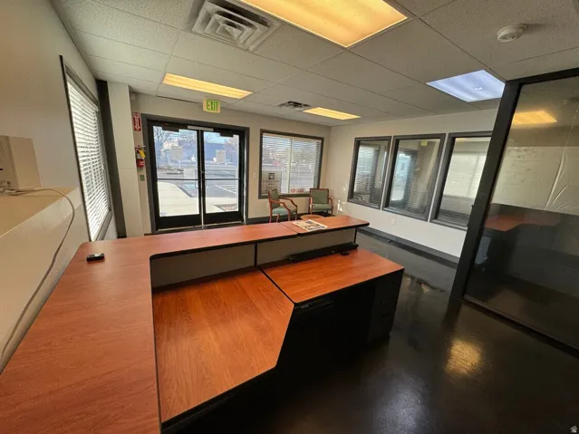 Unit D- Recessed lighting, drop ceiling, wood-finish flooring, glass partition, and front-facing windows