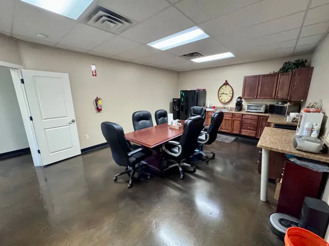 Unit A-0 Bearkroom and kitchen Stained concrete flooring, recessed ceiling lighting, built-in wooden cabinetry, a stainless steel sink, and a durable countertop surface