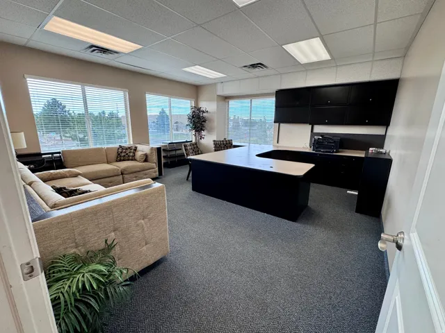 Unit A- Extensive window line with horizontal blinds, built-in cabinetry, drop ceiling, and wall-to-wall carpeting