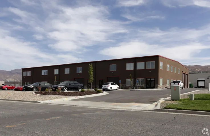 Commercial building with a dark brown exterior, multiple windows, and a paved parking area