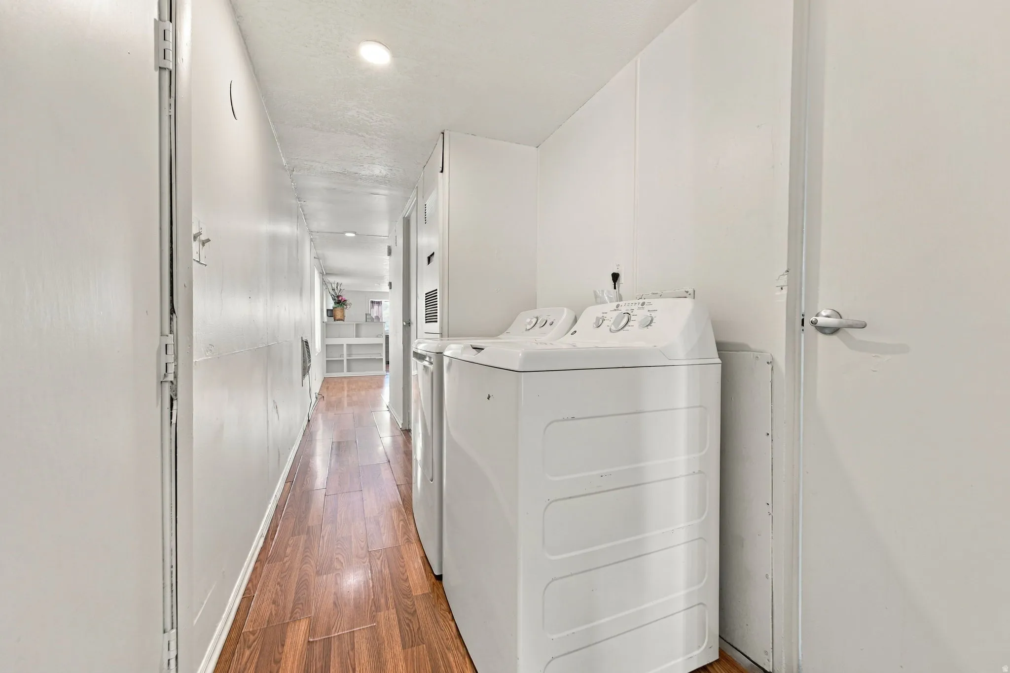 Hallway with wood-finish flooring and recessed lighting