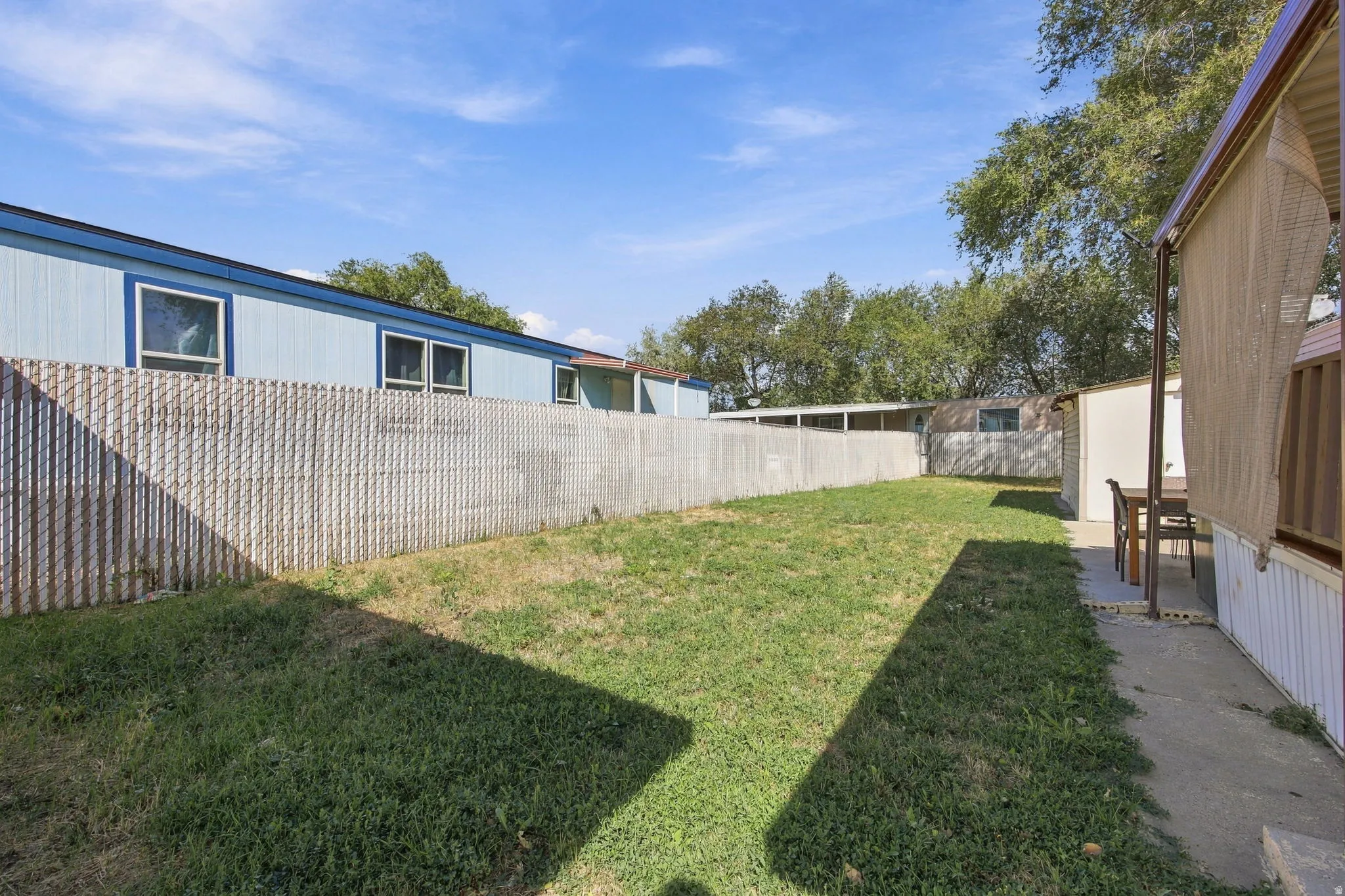 Expansive grassy area with a chain-link fence