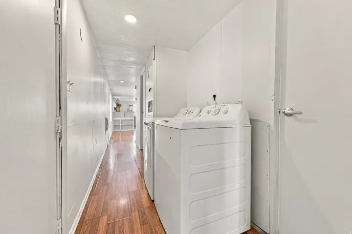 Hallway with wood-finish flooring and recessed lighting