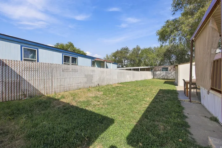 Expansive grassy area with a chain-link fence