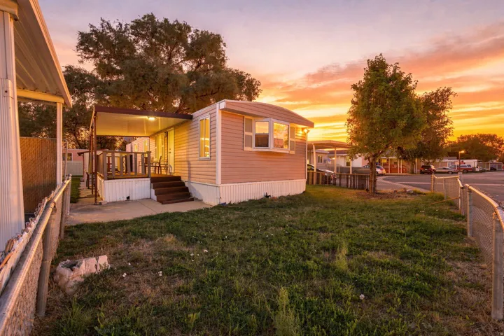 Siding exterior with a covered patio, exterior steps, and a grass lawn