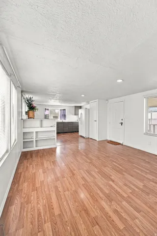 Expansive interior featuring wood-finish flooring, recessed lighting, and built-in shelving