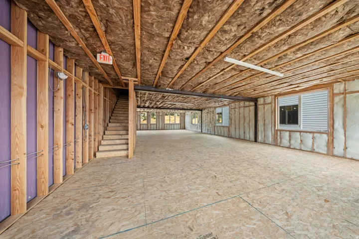 Unfinished interior space featuring exposed wood framing, ceiling insulation, and plywood subflooring