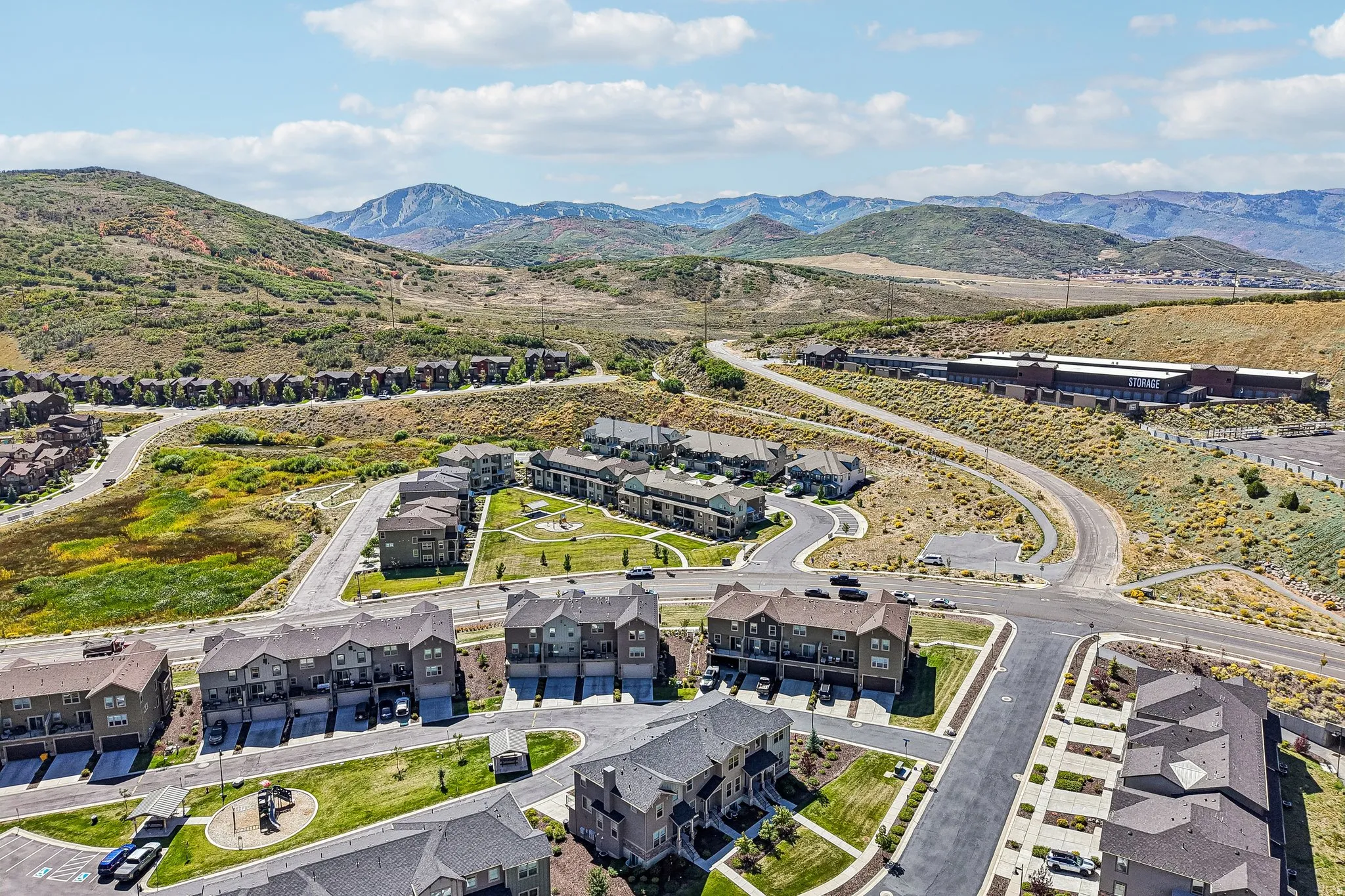 Mountainous terrain, residential developments, winding roadways, and a prominent commercial structure