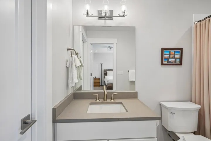 White vanity with an integrated sink, brushed nickel faucet, and a coordinating countertop