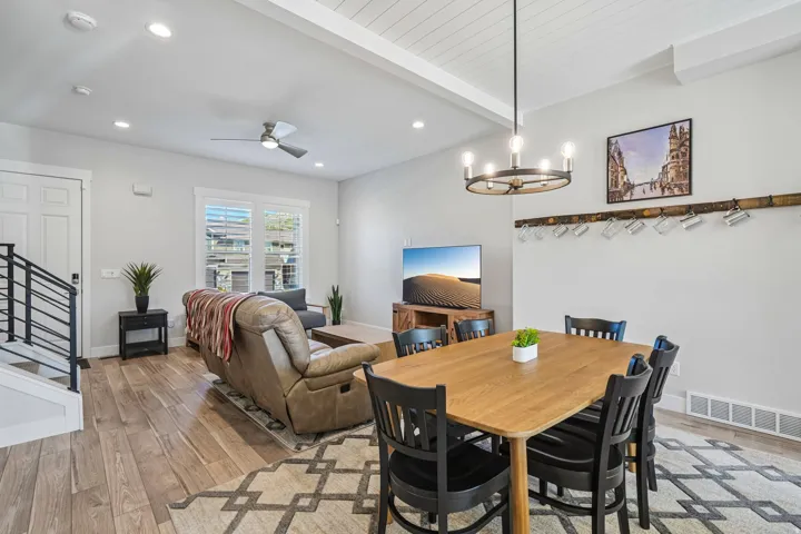 Open-concept living area featuring wood-finish flooring, recessed lighting, and a decorative ceiling fan